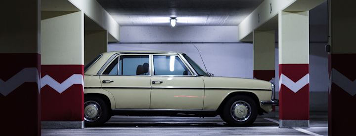 Beige klassisk bil parkerad i ett belyst garage